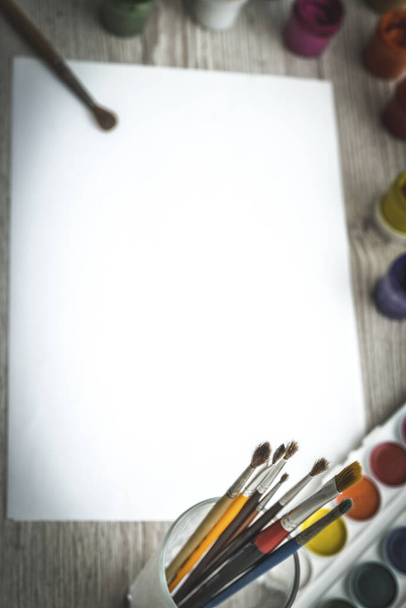 Nástroje pro kreslení, papírnictví, umělecké pracoviště. Barvy a tužky a prázdný papír na dřevěném stole, horní pohled, byt ležel, kopírovací prostor. školní kreslení zásob - Fotografie, Obrázek