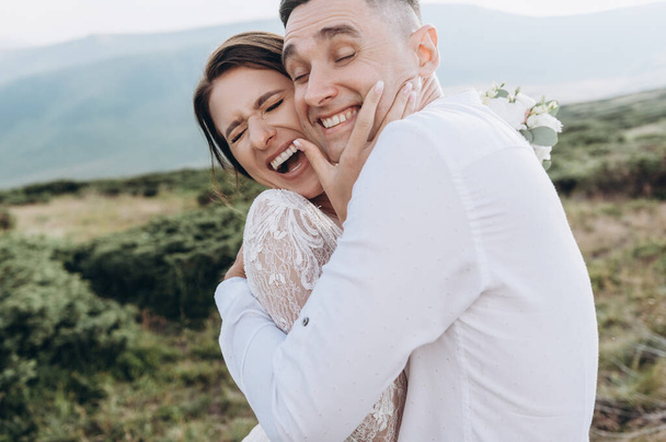 Felici sposi che sorridono, si abbracciano, posano sui monti - Foto, immagini