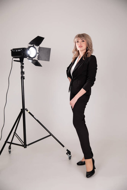 beautiful model posing in professionally equipped studio. Business woman in photo studio with lamps - Fotografie, Obrázek