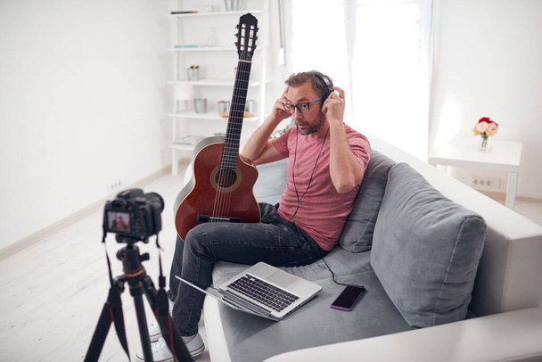 Гитарист делает видео уроки и учебные пособия для интернет vlog веб-сайт классов. - Фото, изображение
