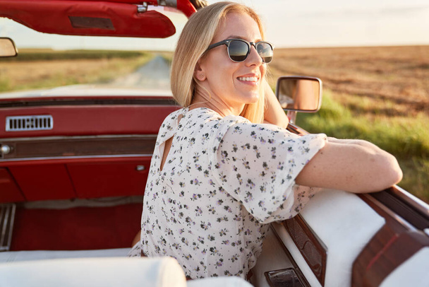 Onnellinen kaunis nainen istuu autossa                                - Valokuva, kuva