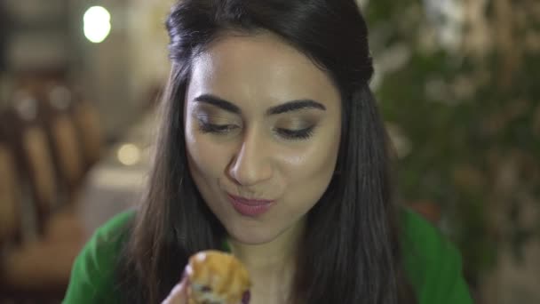 Aantrekkelijke brunet jonge vrouw consumeren vla gebak dessert met vuile handen in chique restaurant in close-up - Video