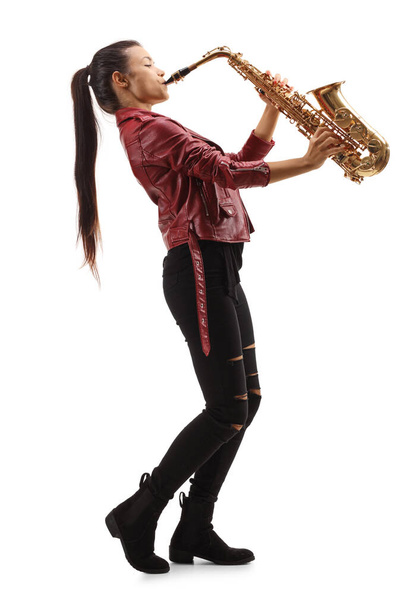 Full length profile shot of a female saxophonist with long black hair playing sax isolated on white background - Foto, Bild