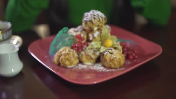 Close up view on tasty delicious cream puff mousse custard pastry pudding cake dessert with berries on square red plate - Footage, Video