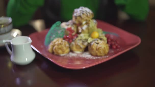 Close-up uitzicht op heerlijke smakelijke room puff custard mousse gebak pudding cake dessert met bessen op vierkante rode plaat - Video