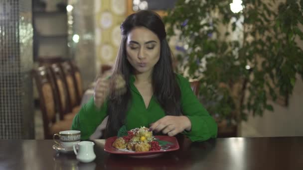 Houkutteleva nuori brunette tyttö innoissaan syöminen iso osa vaniljakastike leivonnaiset jälkiruoka täynnä poskia likaiset kädet - Materiaali, video