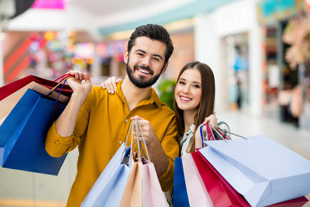 Portrait of his he her she nice attractive lovely glad cheerful cheery couple having fun carrying buyings new things clothes trade brandy bargain spending weekend indoors - Foto, Imagem