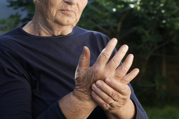 Donna anziana che soffre di dolore alla mano. Sintomi di artrite. - Foto, immagini