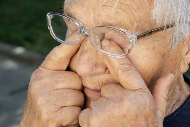 Senior caucasian woman rubbing her eyes under eyeglasses - Photo, Image