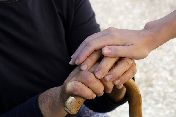 Κρατώντας τα χέρια. Μια φωτογραφία νέων και ηλικιωμένων χεριών. Έννοια της ελπίδας, φροντίδα, αγάπη και υποστήριξη. - Φωτογραφία, εικόνα