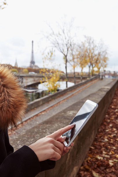 Mädchen mit Handy mit Pariser Stadthintergrund, Seine und Eiffelturm. - Foto, Bild