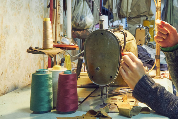 Vrouw op maat met behulp van retro naaimachine thuis, hobby concept. - Foto, afbeelding