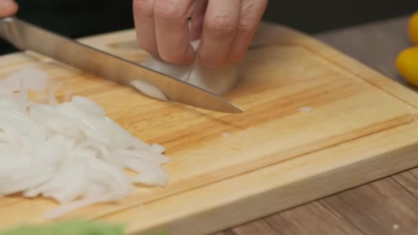 Chef professionnel prépare et coupe l'oignon blanc. Fermez au ralenti - Séquence, vidéo