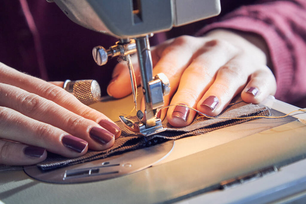 Woman tailor using retro sewing machine at home, hobby concept. - 写真・画像