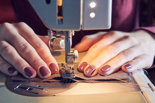 Woman tailor using retro sewing machine at home, hobby concept. - Foto, afbeelding