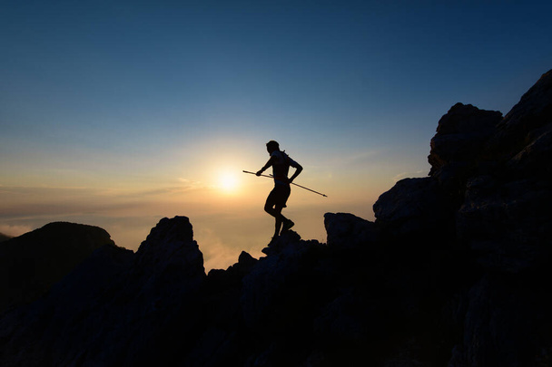 Sky runner σε σιλουέτα στο ηλιοβασίλεμα ανάμεσα στα βράχια - Φωτογραφία, εικόνα