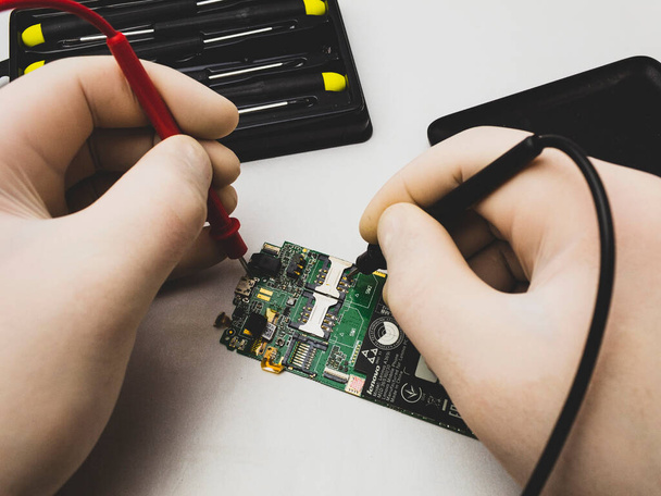 Mobile phone repair with tester and screwdriver - Foto, Bild