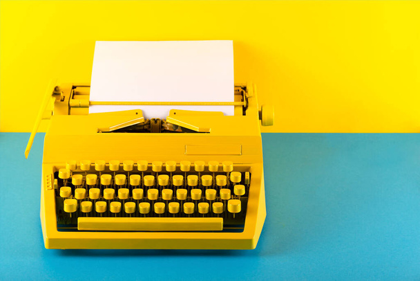 Machine à écrire jaune vif sur fond jaune. Concept de créativité - Photo, image