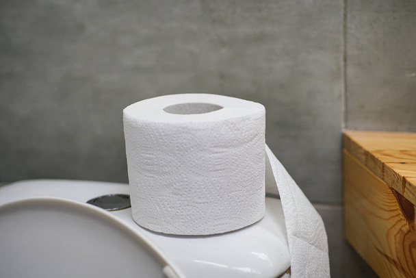 Papier toaletowy jest na pokrywie toalety w łazience. - Zdjęcie, obraz