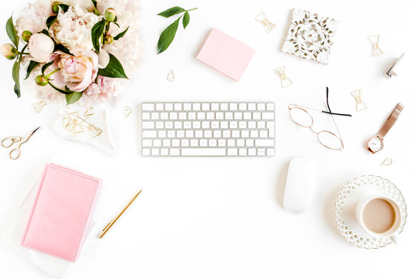 Flat lay womens office desk. Female workspace with computer, pink peonies bouquet, accessories on white background. Top view feminine background. - Foto, imagen