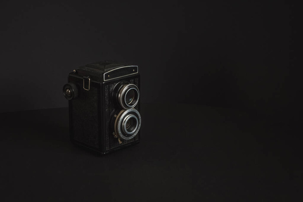 Old analog camera with two lenses on a black background. Copy space. - Photo, Image