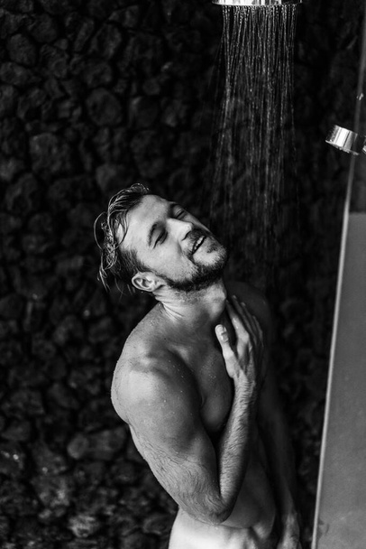 Man taking a shower washing hair with shampoo product under wate - Fotografie, Obrázek