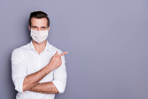 Portrait of his he attractive healthy guy wearing safety mask demonstrating copy space stop influenza pandemia healthcare therapy diagnostic illness sickness disease isolated gray color background - Fotografie, Obrázek