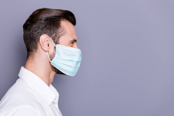 Close-up profile side view portrait of his he attractive healthy guy employee wearing safety gauze mask stop influenza pandemia social distance copy space isolated gray color background - Fotografie, Obrázek