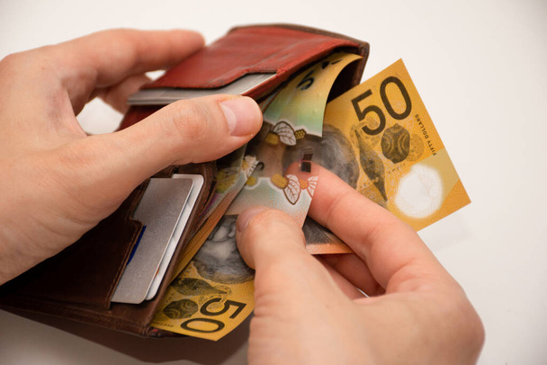 Руки, що тримають шкіряний гаманець з австралійськими банкнотами по 50 доларів. Концепція фінансів та платежів
. - Фото, зображення