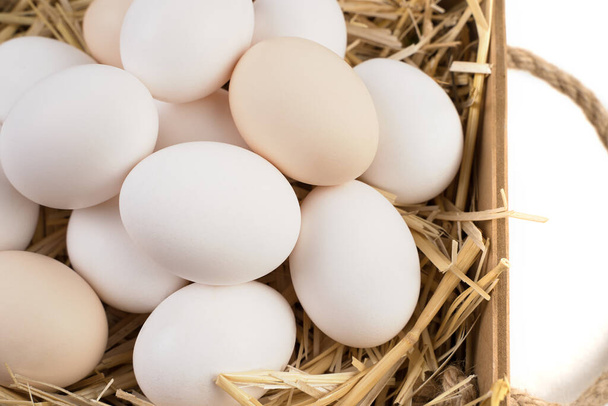 Basket full of chicken eggs lying on straw side View. - Photo, Image