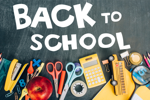 Olgun elma, hesap makinesi ve okul malzemelerinin en üst görünümü siyah karatahtada ve okula geri dönüş yazılarıyla birlikte.  - Fotoğraf, Görsel