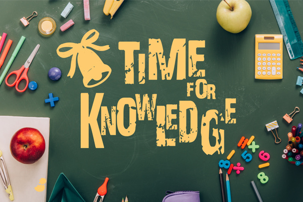 κορυφαία άποψη του πλαισίου με ώριμα μήλα και σχολικά είδη σε πράσινο chalkboard με χρόνο για γράμματα γνώσης  - Φωτογραφία, εικόνα