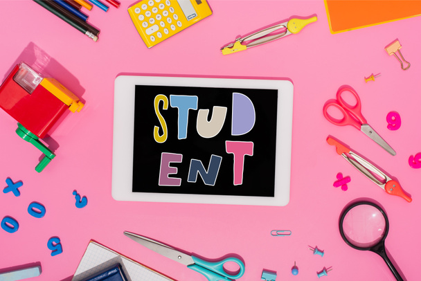 vista superior de la tableta digital con letras de estudiante en la pantalla cerca de papelería escolar en rosa  - Foto, imagen