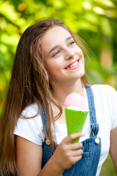 retrato de una hermosa adolescente con un cono de helado de fresa en sus manos - Foto, Imagen