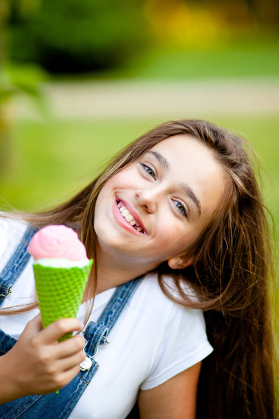 retrato de una hermosa adolescente con un cono de helado de fresa en sus manos - Foto, Imagen