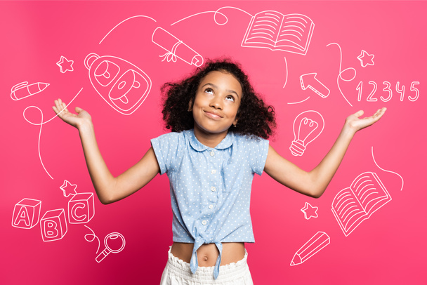 curly african american kid showing shrug gesture near illustration on pink - Photo, Image