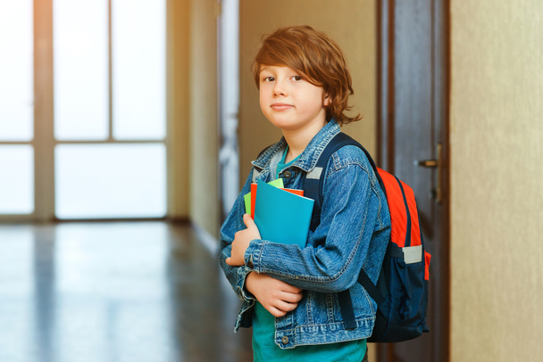 Schoolboy with schoolbag and books in the school. Education concept. Back to school. Schoolkid going to class. Stylish boy with backpack. Boy ready to study. - Foto, Bild
