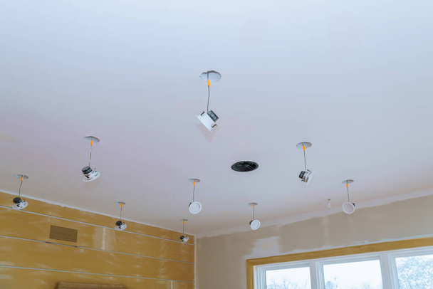Primo piano una mano cambia una luce LED in una preparazione elegante per l'installazione di illuminazione interna della lampada a soffitto - Foto, immagini