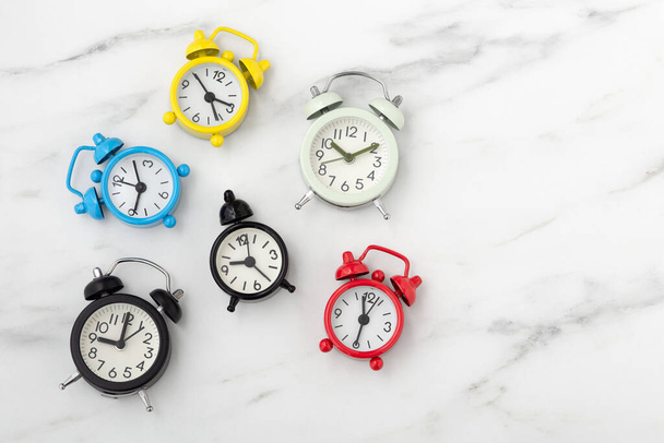 Klokken met verschillende tijd en kleur op tafel, tijdconcept - Foto, afbeelding