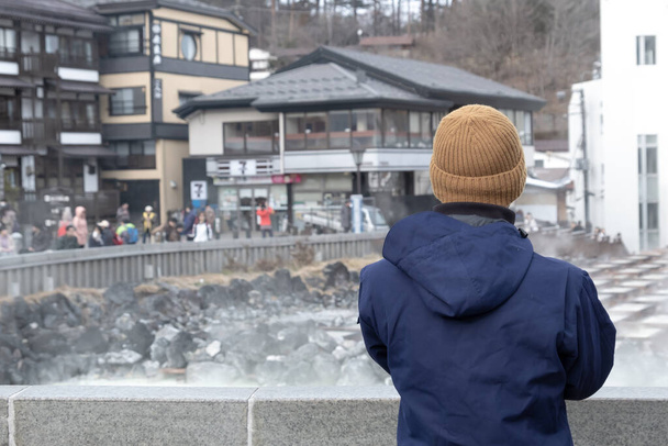 Back view of tourist traveler man sightseeing Gorące źródła w kusatsu onsen zimą Japonia  - Zdjęcie, obraz