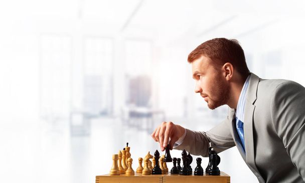 Businessman moving chess figure in chessboard - 写真・画像