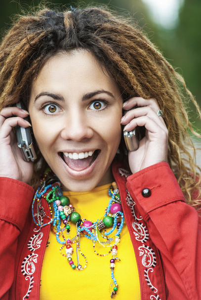 donna sorridente che parla su due telefoni cellulari
 - Foto, immagini