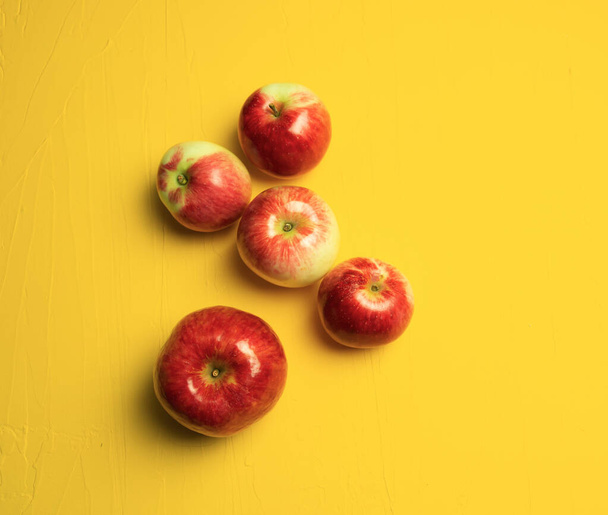 Rode rijpe appels op een gele achtergrond. Begrepen, ruimte. Bovenaanzicht - Foto, afbeelding