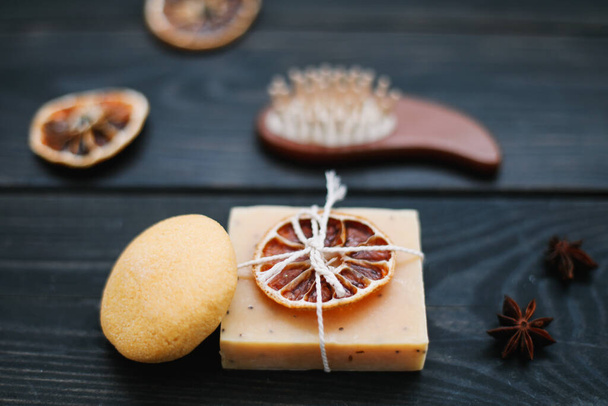 Natural handmade soap with dried slices of oranges on a dark background. Concept of Spa, body and skin care.   - Fotografie, Obrázek