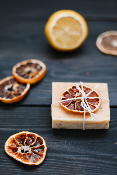 Natural handmade soap with dried slices of oranges on a dark background. Concept of Spa, body and skin care.   - Photo, Image