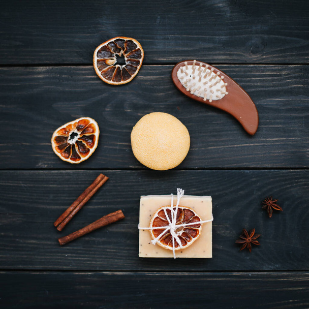 Natural handmade soap with dried slices of oranges and cinnamon on a dark background. Concept of Spa, body and skin care.   - Foto, Imagen