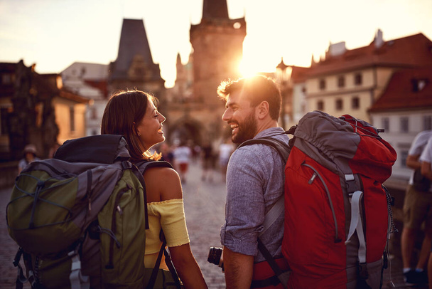 Young tourist couple and love on a city streets on a beautiful sunset - Фото, изображение
