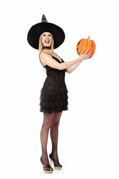 fiatal és csinos szőke boszorkány nő Halloween tök fehér elszigetelt háttér - Fotó, kép