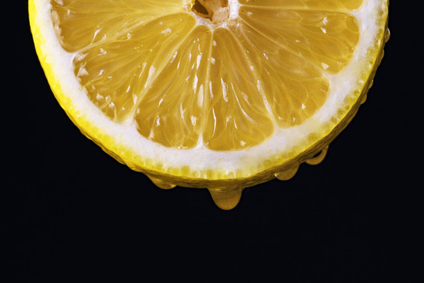 Saftige Scheibe gelbe Zitrone mit einem Tropfen Saft. - Foto, Bild