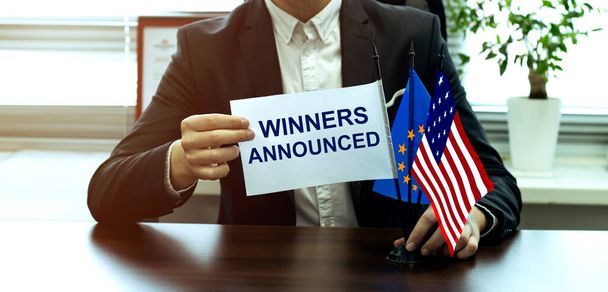man take a flag with text Winners Announced with flags on the office background - Photo, Image
